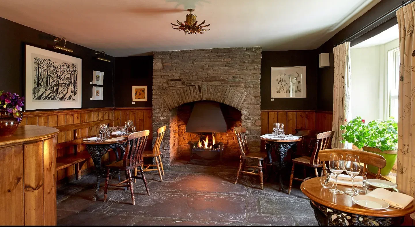 Cozy dining room with fireplace at The Walnut Tree Inn, restaurant in Wales.