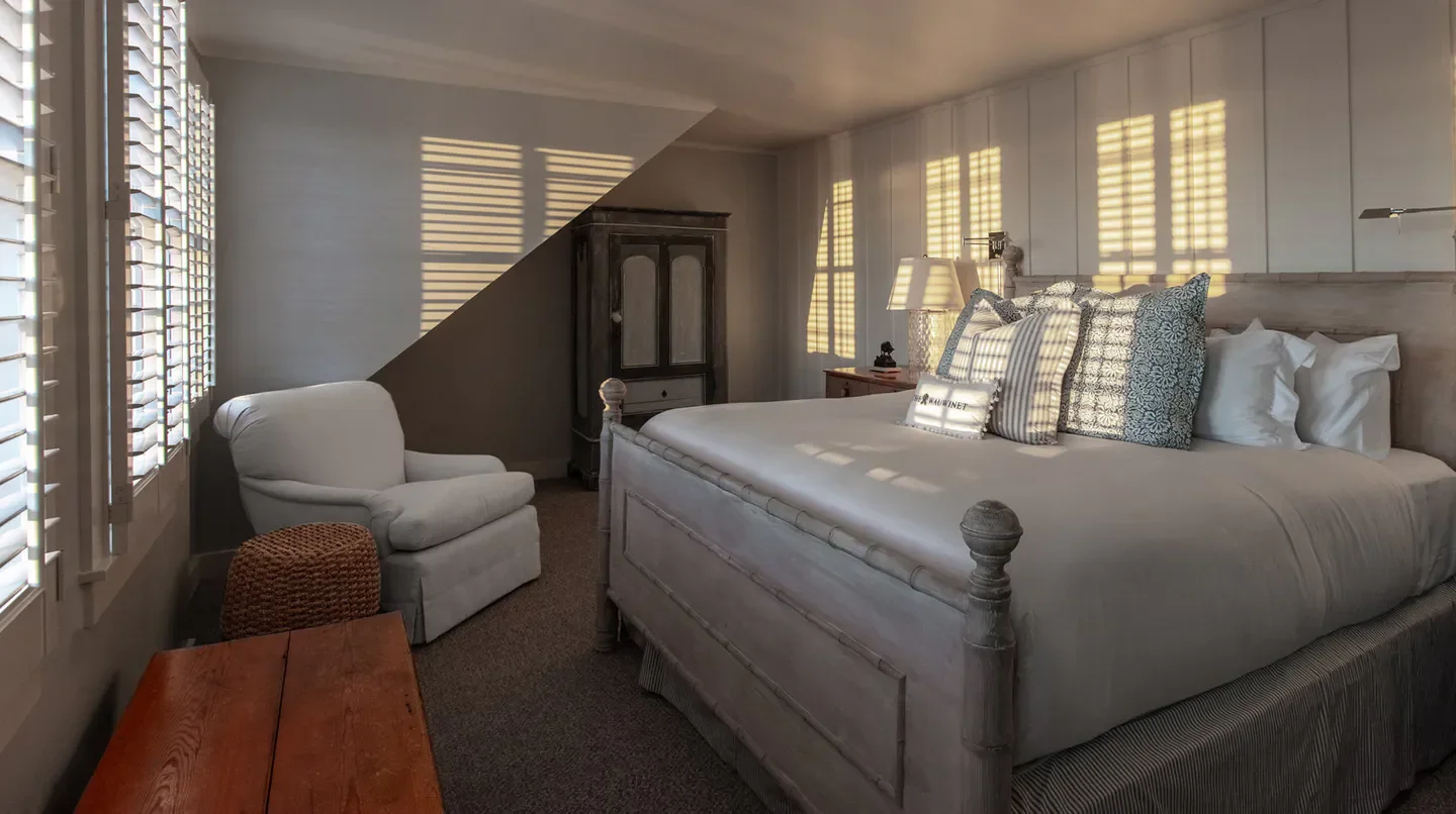 Cozy bedroom at The Wauwinet in Nantucket, showcasing soft light and stylish decor.