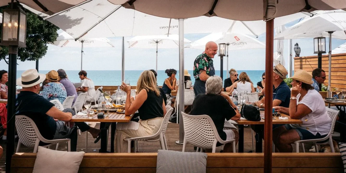 Outdoor dining at Three Seven Two in Auckland, enjoying a seaside restaurant experience.