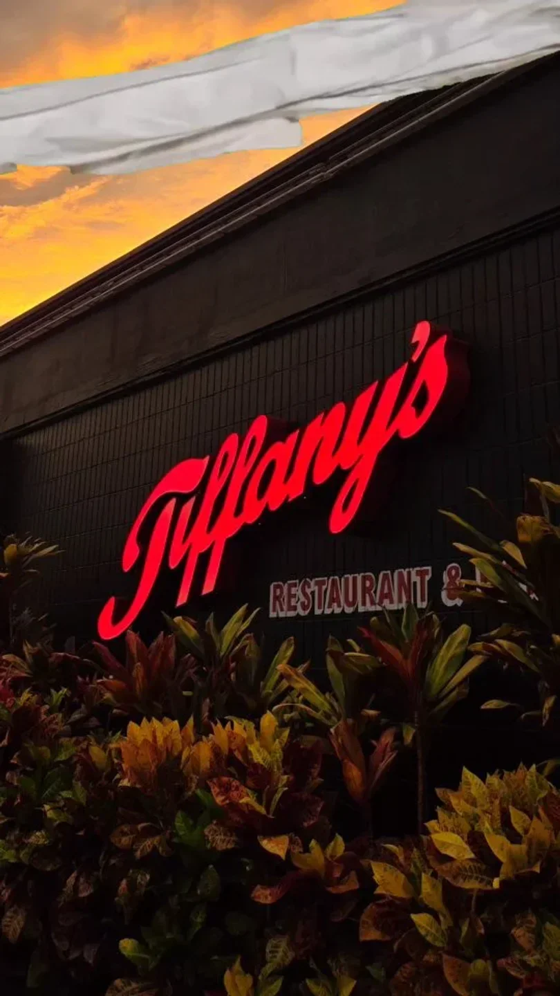 Glowing red Tiffany's restaurant sign in Maui, Restaurant & Bar, sunset in the background