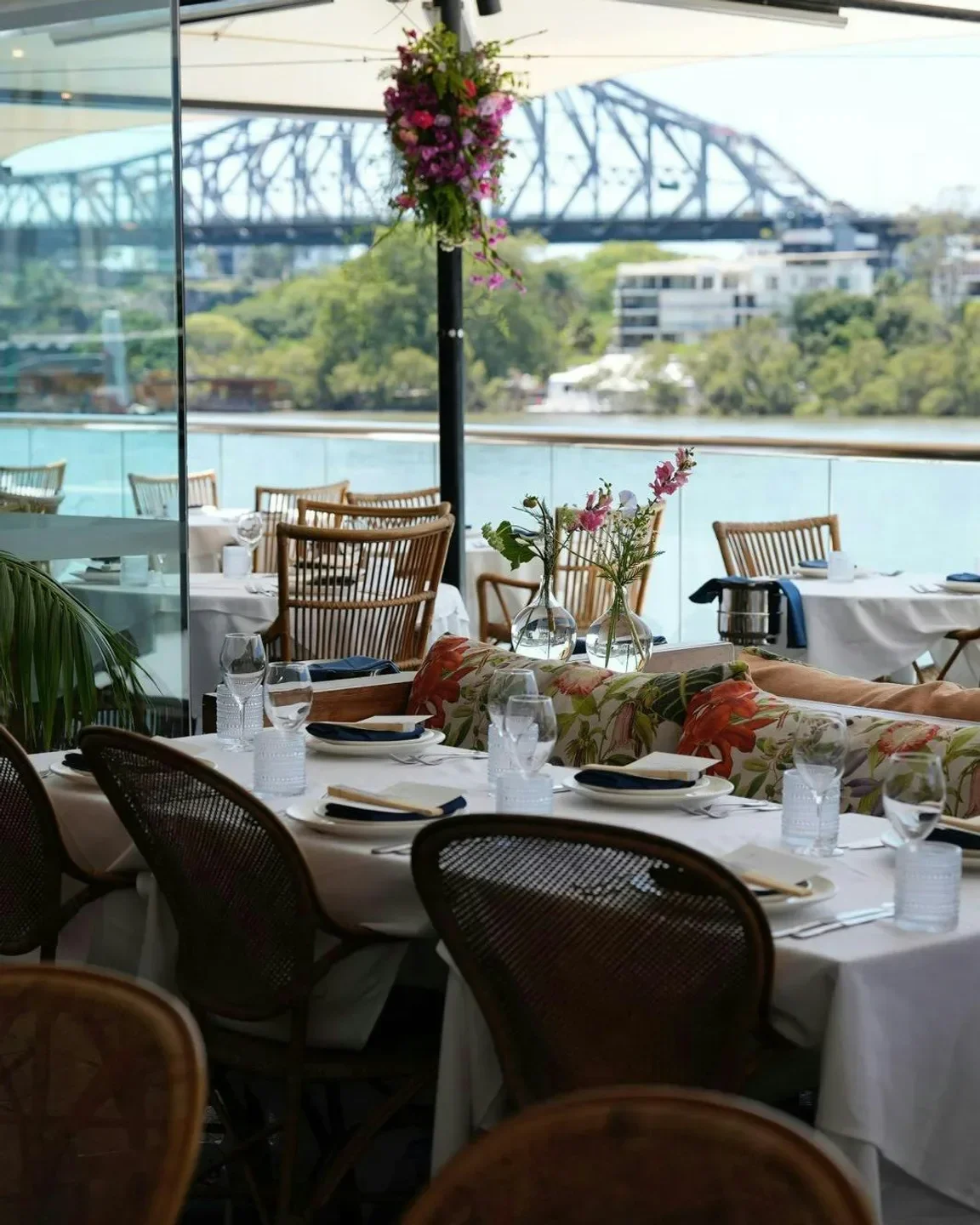 Outdoor dining at Tillerman restaurant in Brisbane with river and bridge views