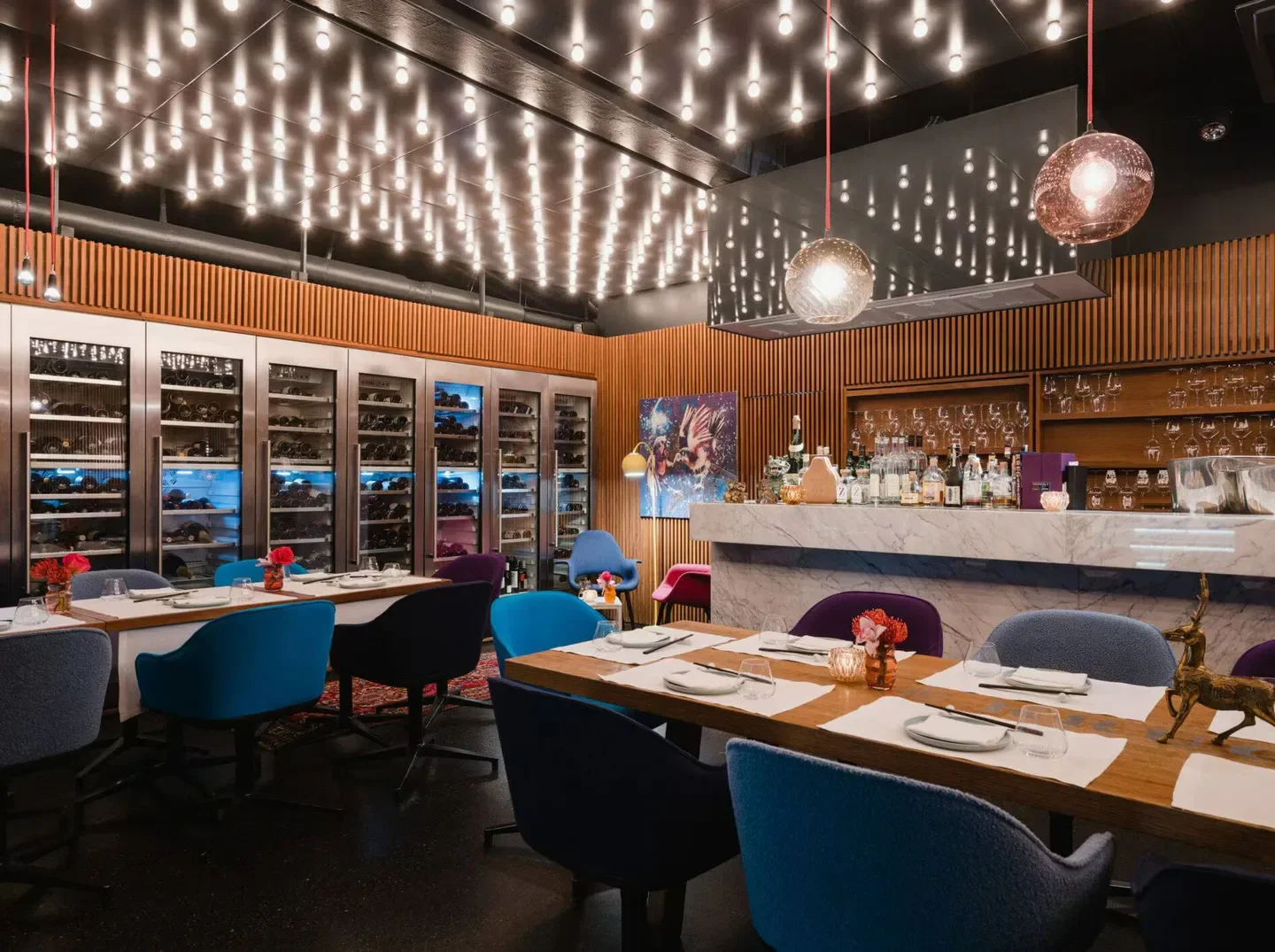 Interior of Tim Raue restaurant in Berlin, featuring elegant dining and wine display.