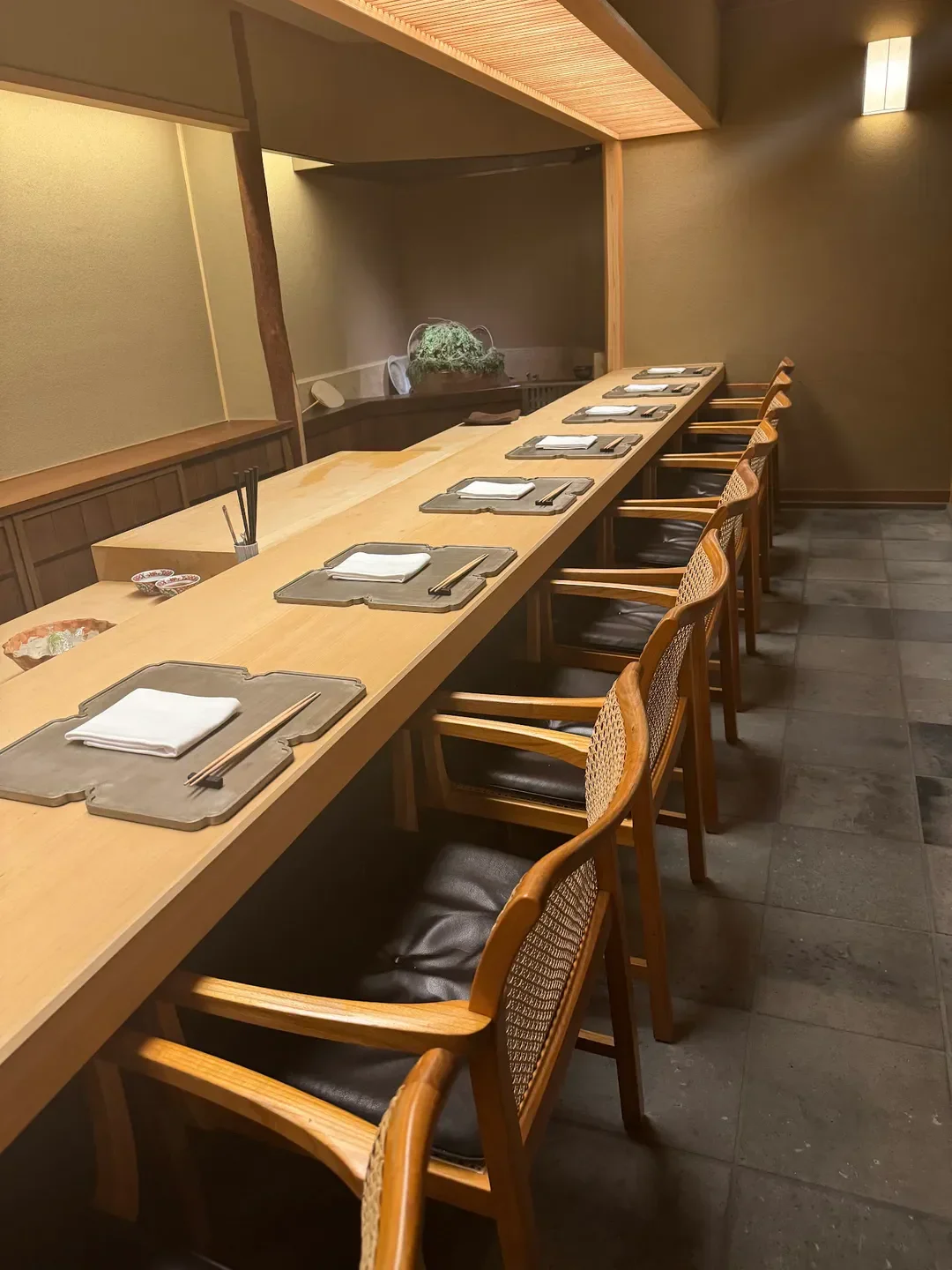 Elegant dining space at Tokuha Motonari restaurant in Kyoto with prepared place settings.
