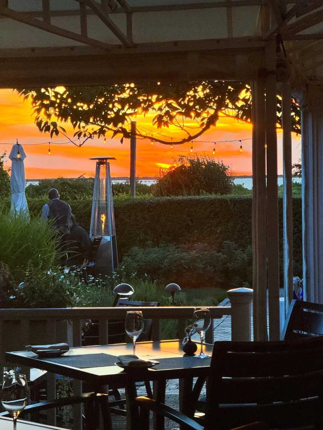 Sunset view from Topper's in Nantucket, with outdoor seating and a vibrant sky.
