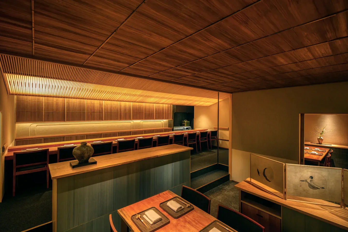 Cozy interior of Torakuro restaurant in Tokyo, featuring wooden ceilings and intimate dining spaces.