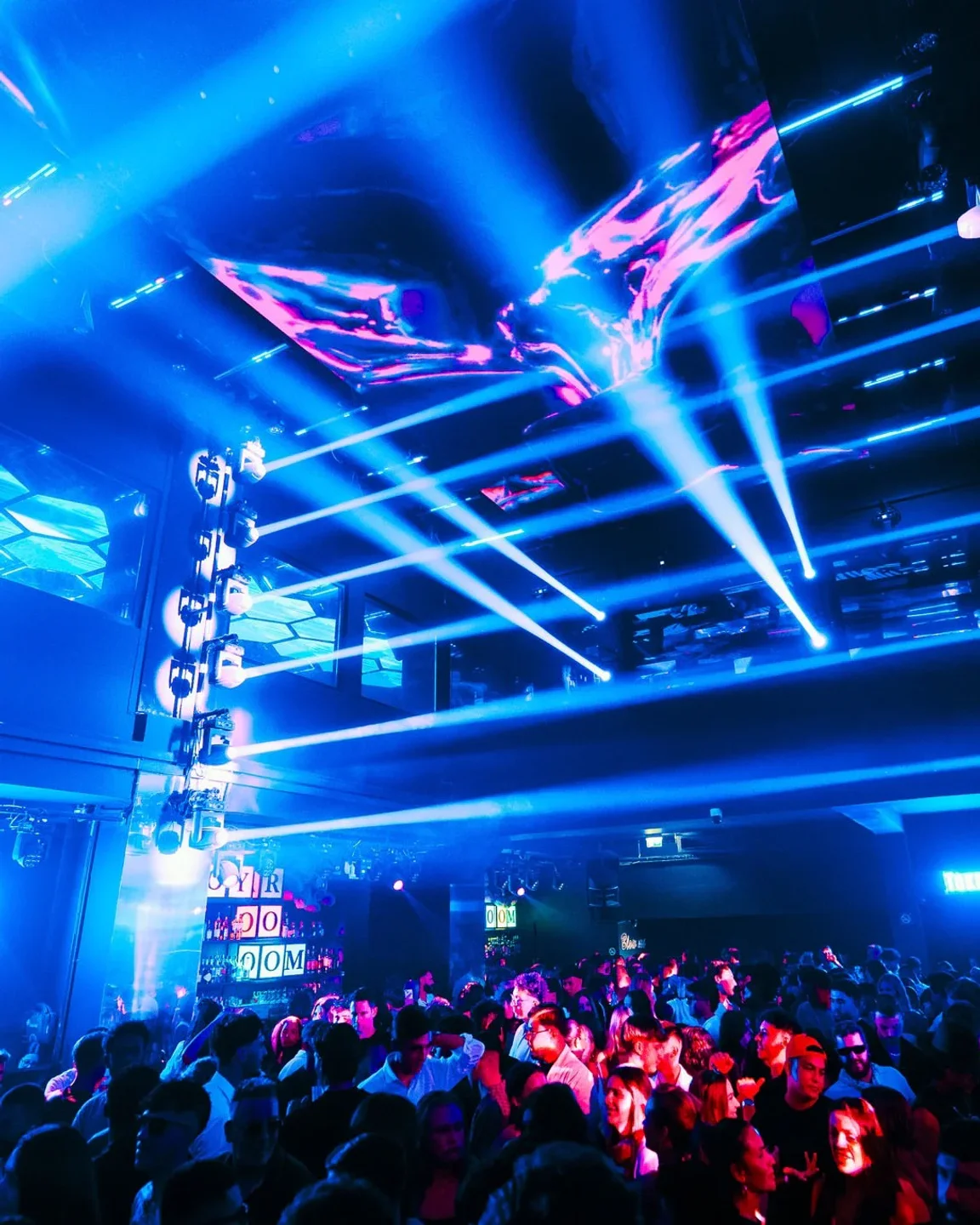 Energetic crowd dancing under blue lights and lasers at Toy Room Club Malta