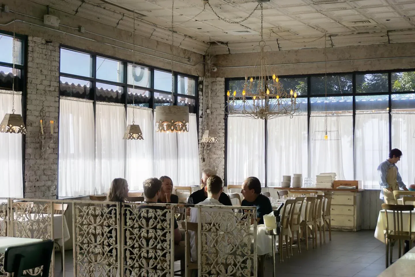 Elegant dining room at Tratto in Phoenix with hanging lamps and large windows
