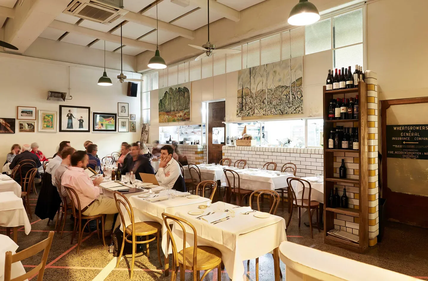 Interior of Trattoria Emilia in Melbourne with tables set and customers dining.
