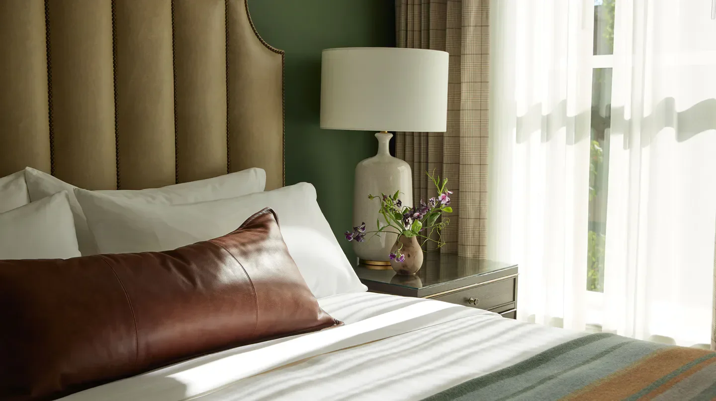Cozy bedroom at the Tributary Hotel in Portland, featuring stylish decor and natural light.