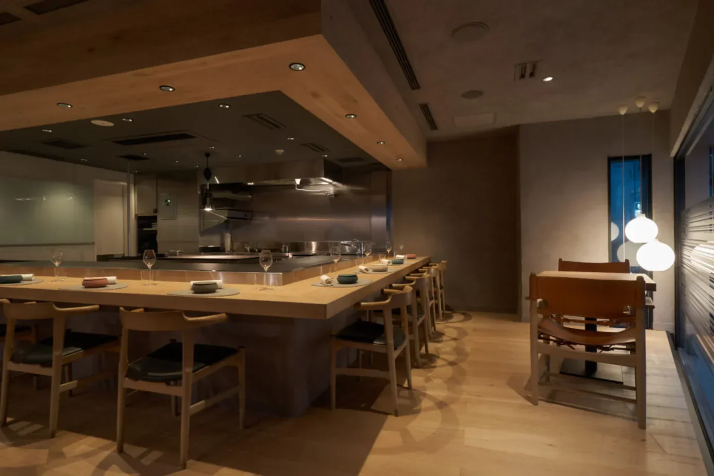 Interior of TROIS VISAGES restaurant in Tokyo, showcasing a minimalist dining space.