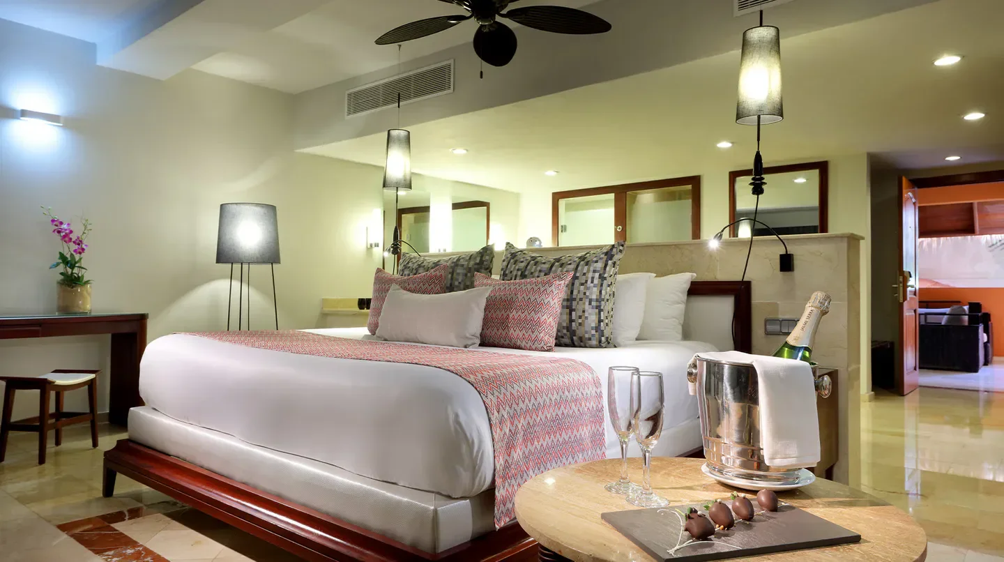 Luxurious suite at TRS Turquesa Hotel in Macau, featuring champagne and a king-sized bed.