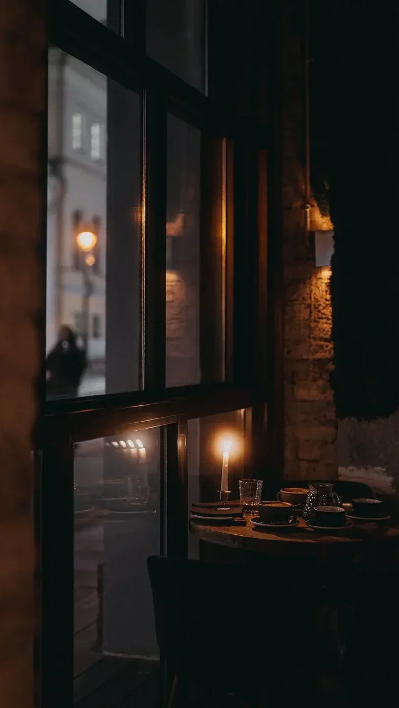 Cozy table setting with a candle at Ugolek restaurant in Moscow, with city view.