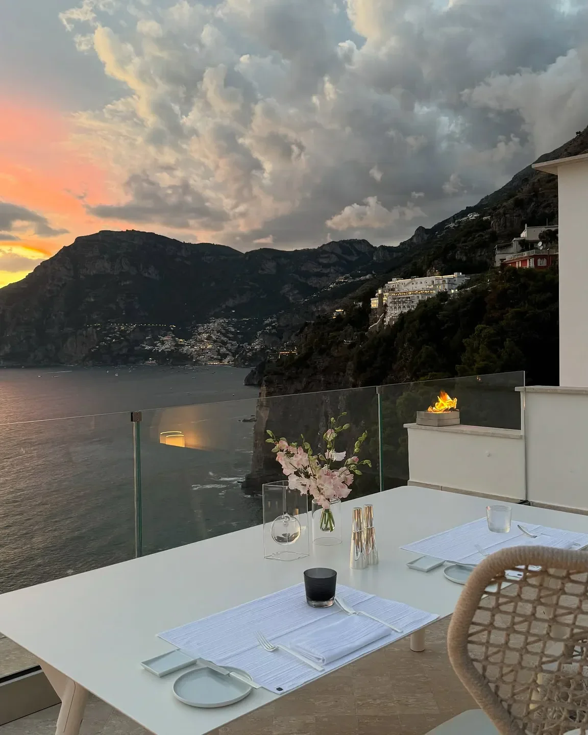 Elegant dining at Un Piano nel Cielo, Amalfi Coast, with sunset views and ocean backdrop.