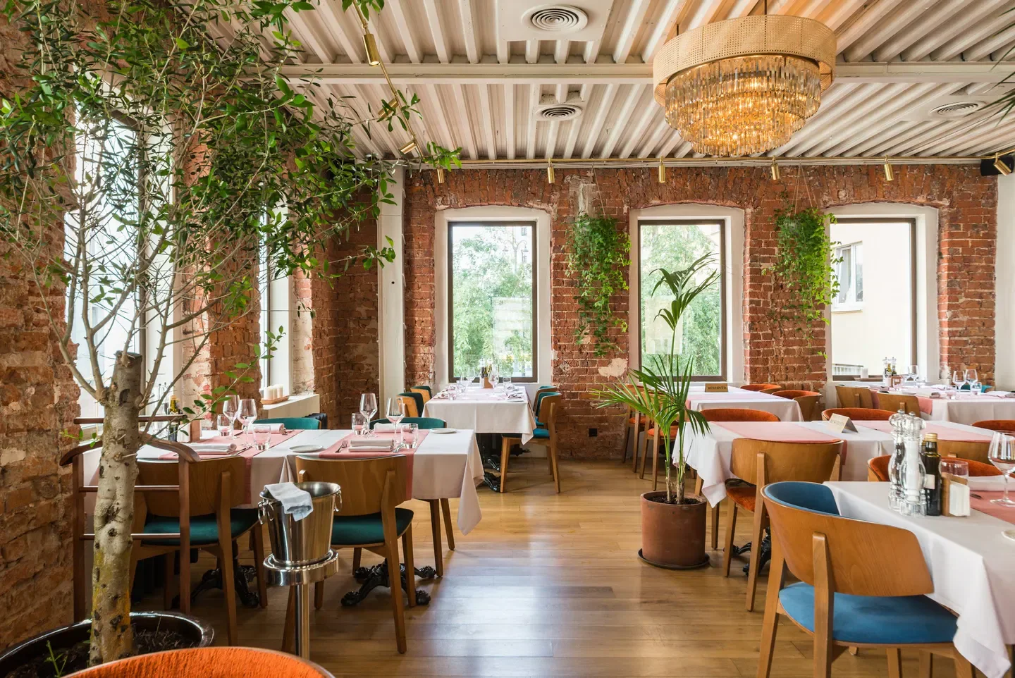 Interior of Unica Ristorante in Moscow with brick walls, tables and plants.