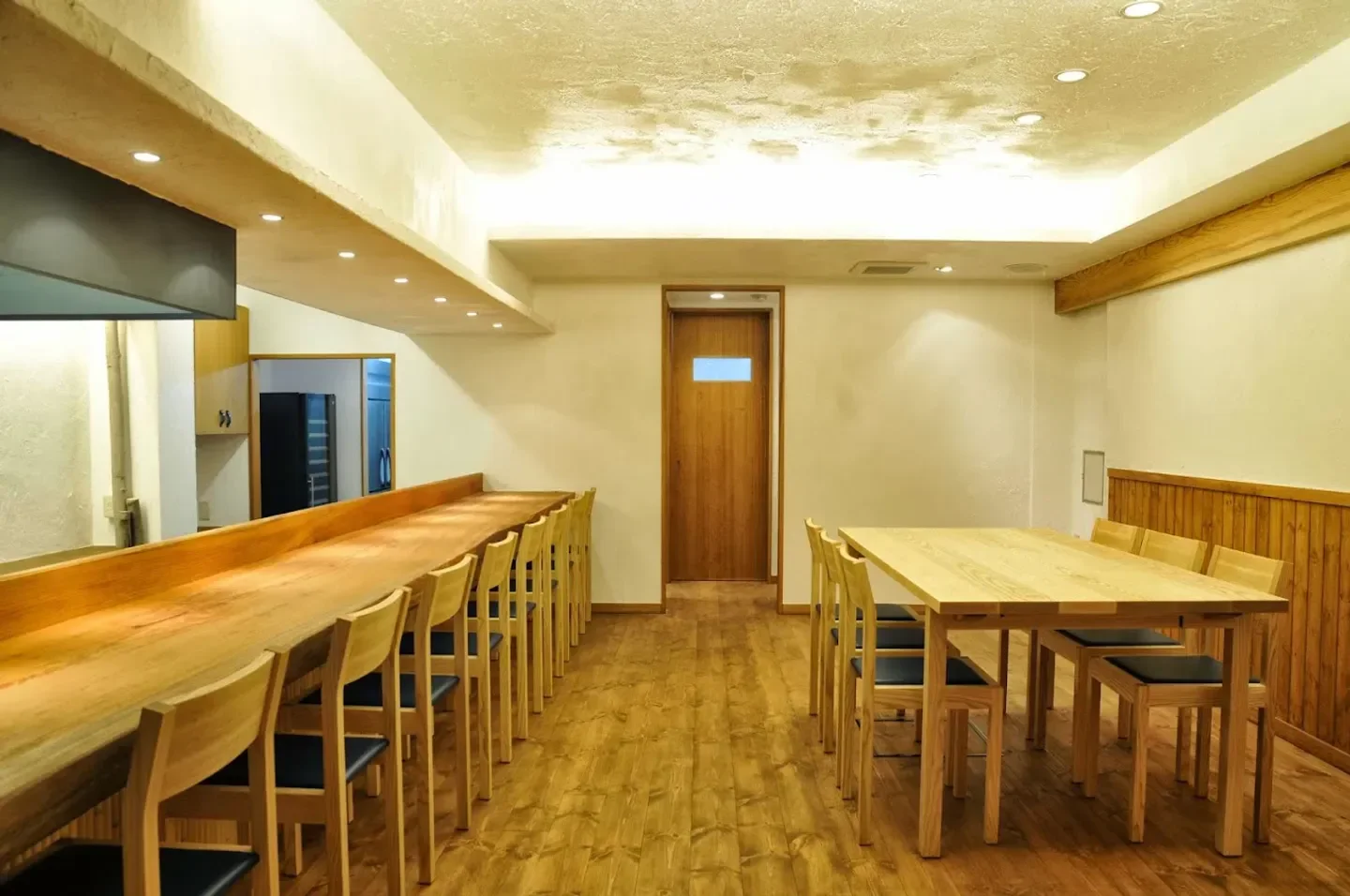 Elegant dining space at Utsubohommachi Gaku restaurant in Osaka, Japan, featuring wooden tables.