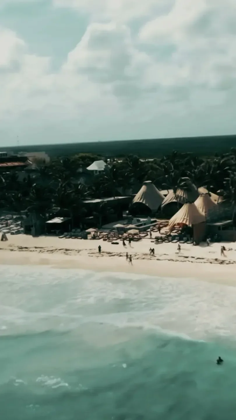 Aerial view of Vagalume restaurant on the beach in Tulum, Mexico, with ocean waves