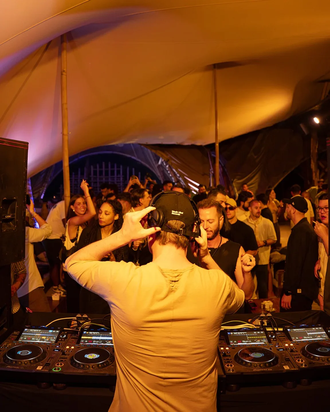 DJ at Vagalume nightclub in Tulum, Mexico, playing music for a crowd of people dancing and enjoying the night.