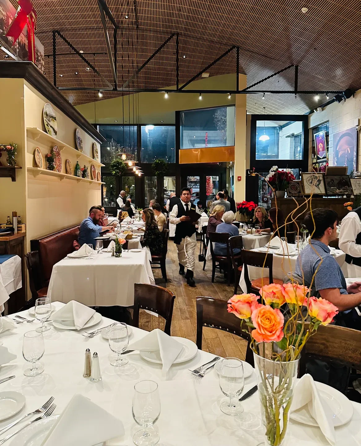 Interior of Valter's Osteria in Salt Lake City with diners and floral arrangements