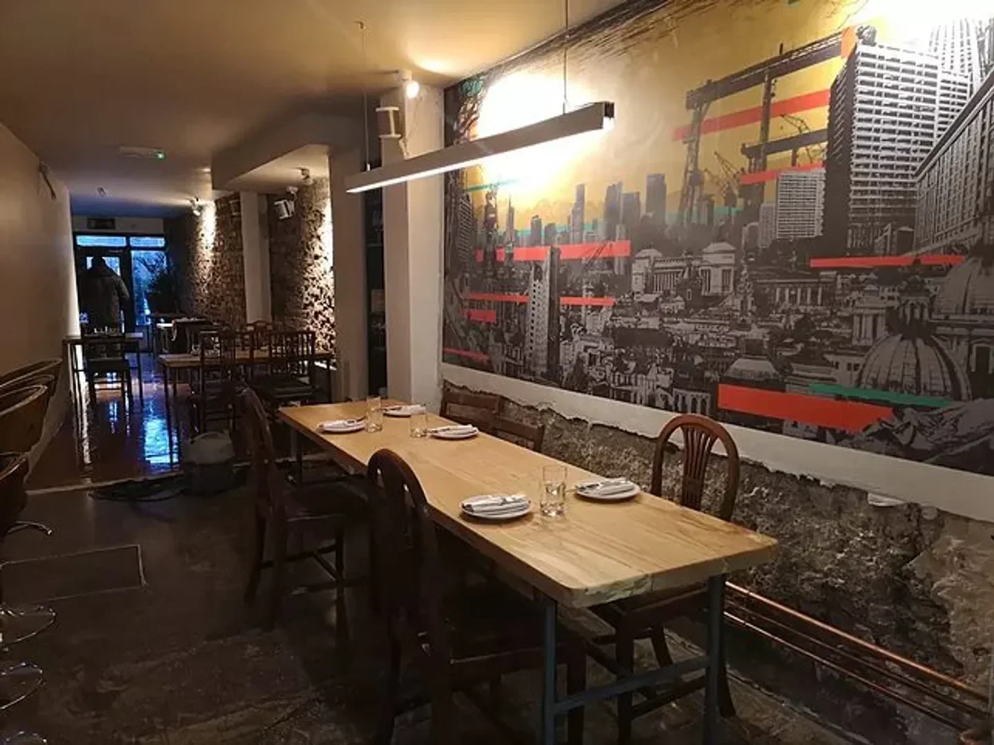 Interior of Variety Jones restaurant in Dublin, with urban mural and wooden tables