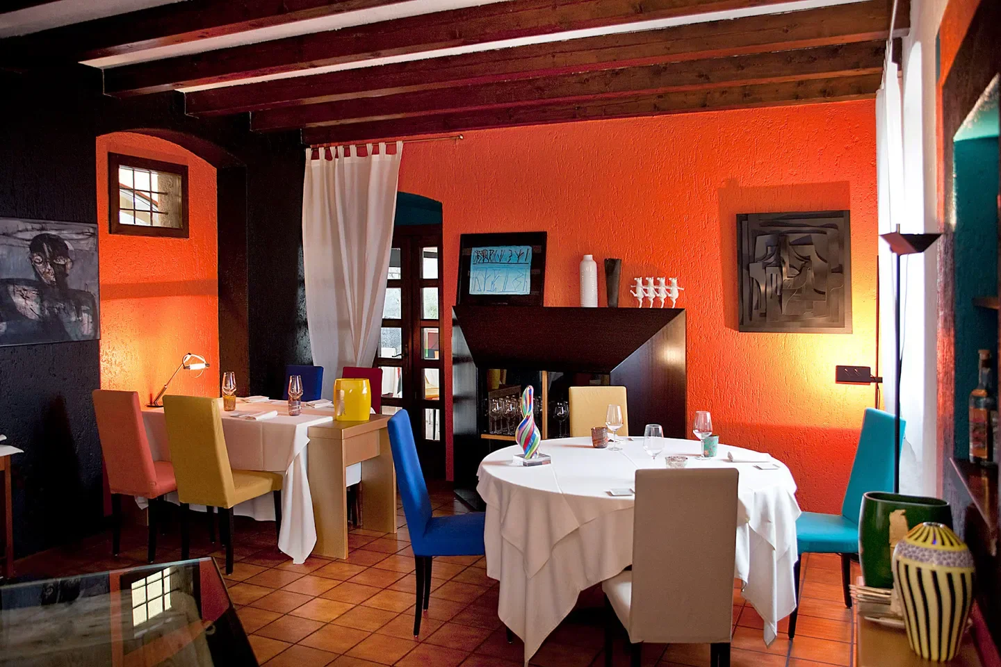 Interior of Vecchia Malcesine restaurant on Lago di Garda with colorful decor and tables.