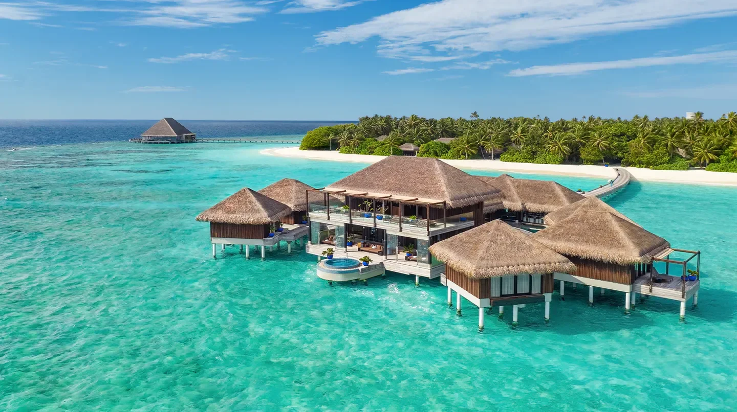Overwater villas at Velaa Private Island in Maldives, surrounded by turquoise waters.