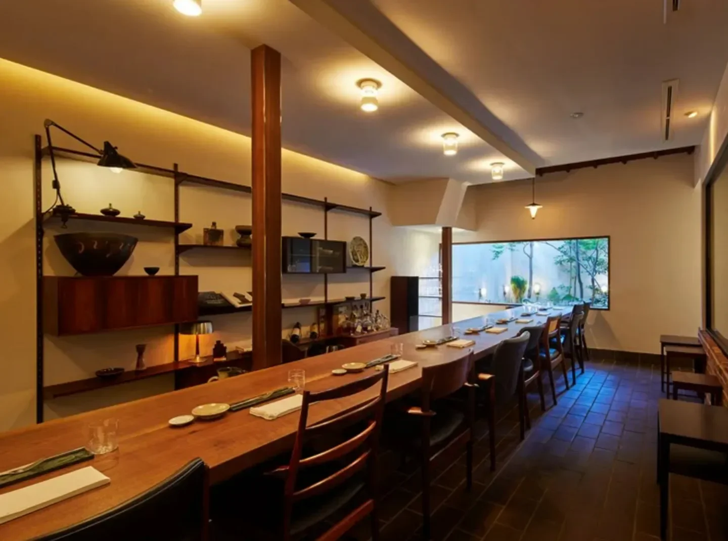 Interior dining space at Vena restaurant in Kyoto, featuring a long wooden table.