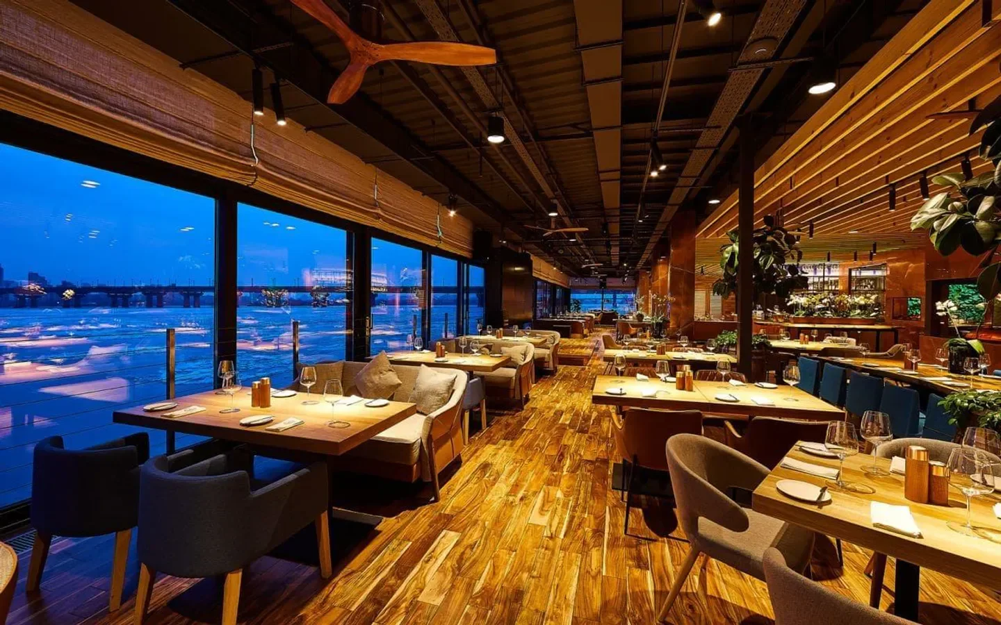 Interior of Veranda on the River in Kyiv, showcasing elegant dining with a river view