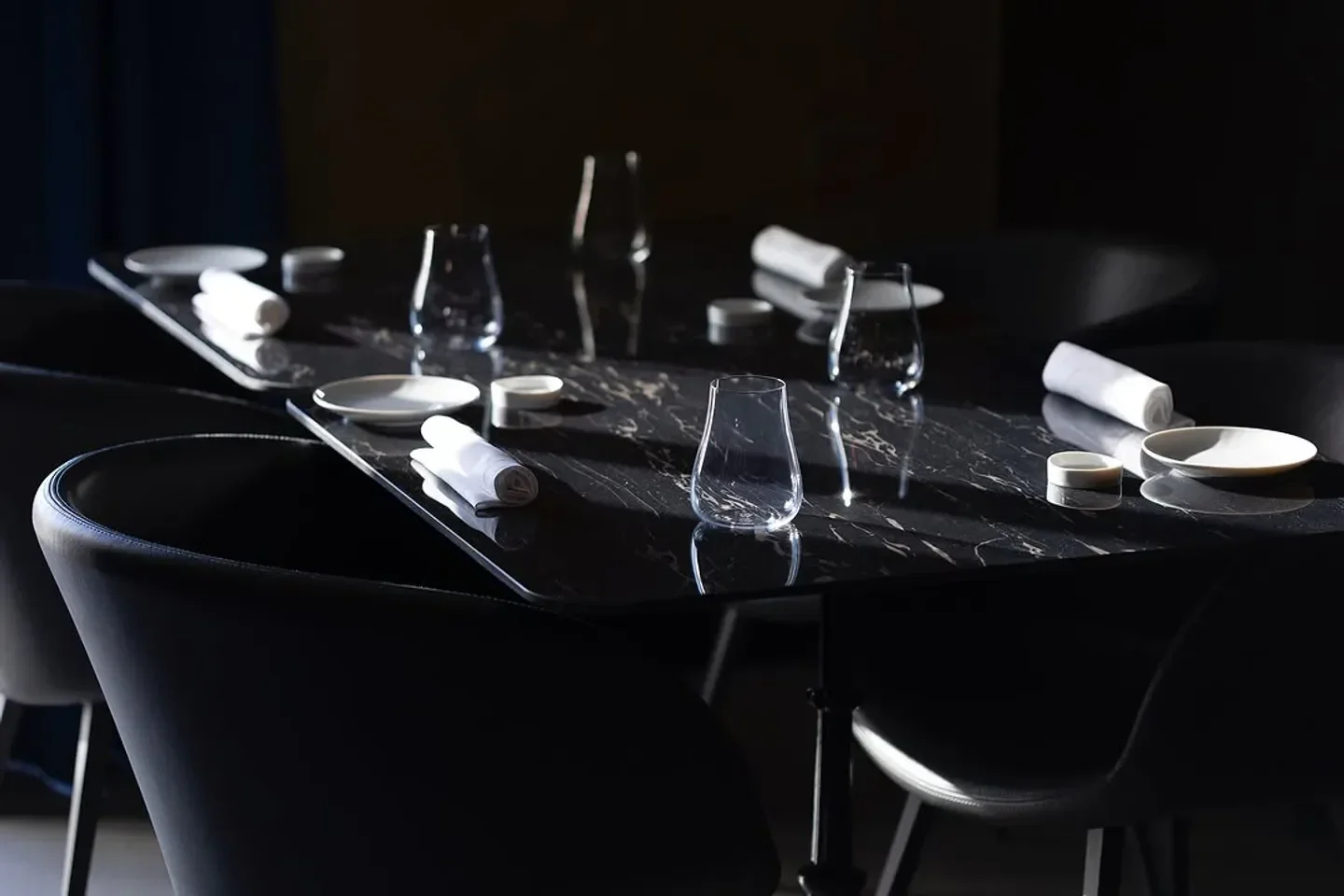 Elegant dining at Veritas in Napoli: stylish tablescape with black marble and fine glassware.