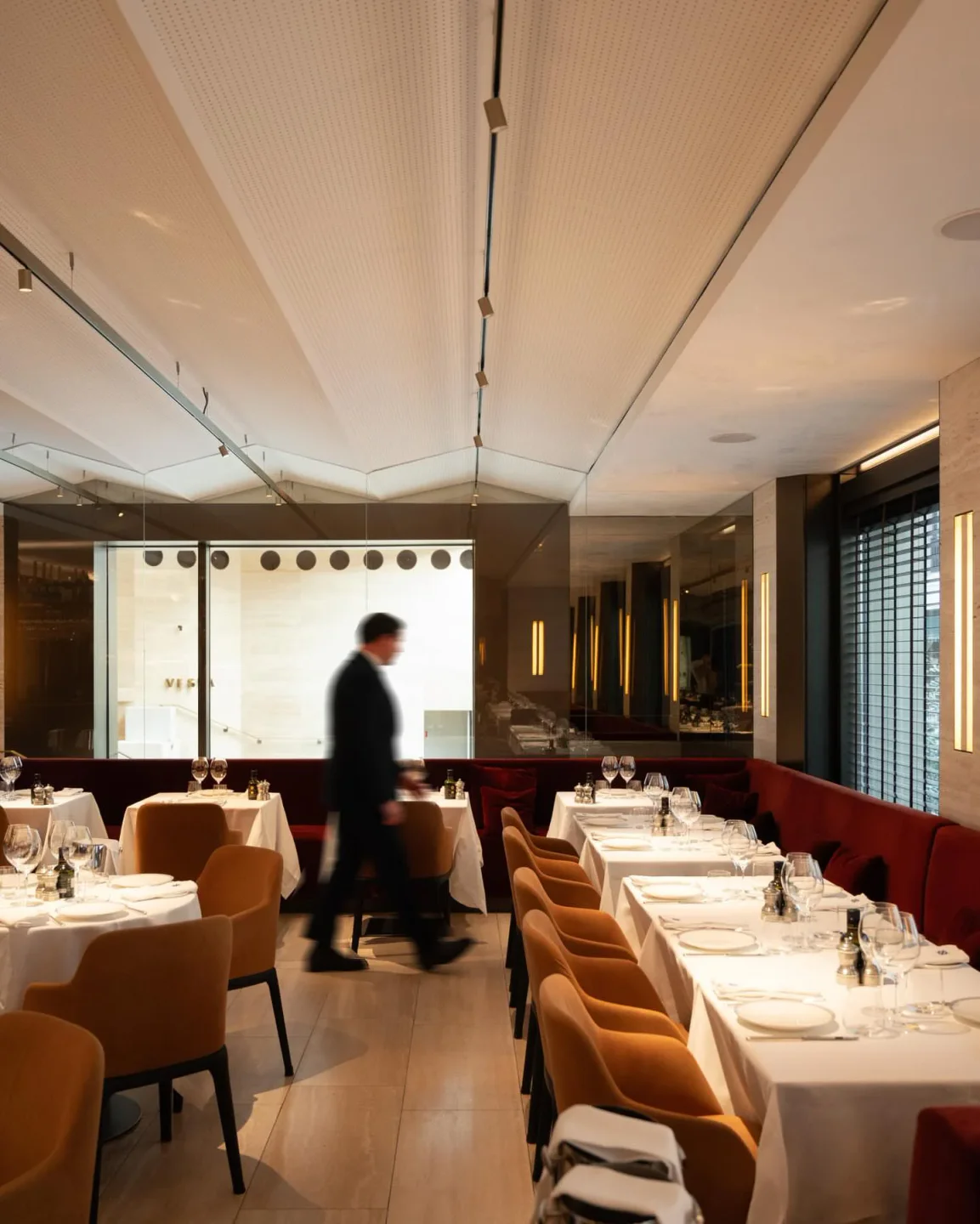 Vesta restaurant in Porto Cervo featuring elegant dining tables with white tablecloths and warm lighting.