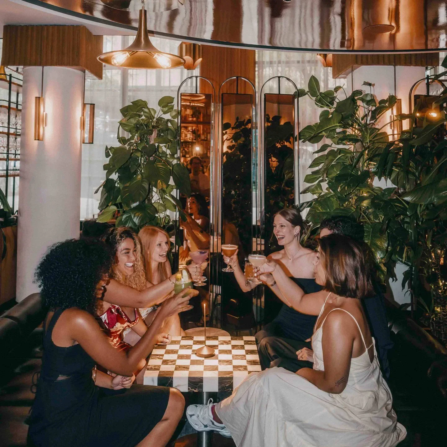 Friends toasting at Vestry restaurant in New York City with cocktails.