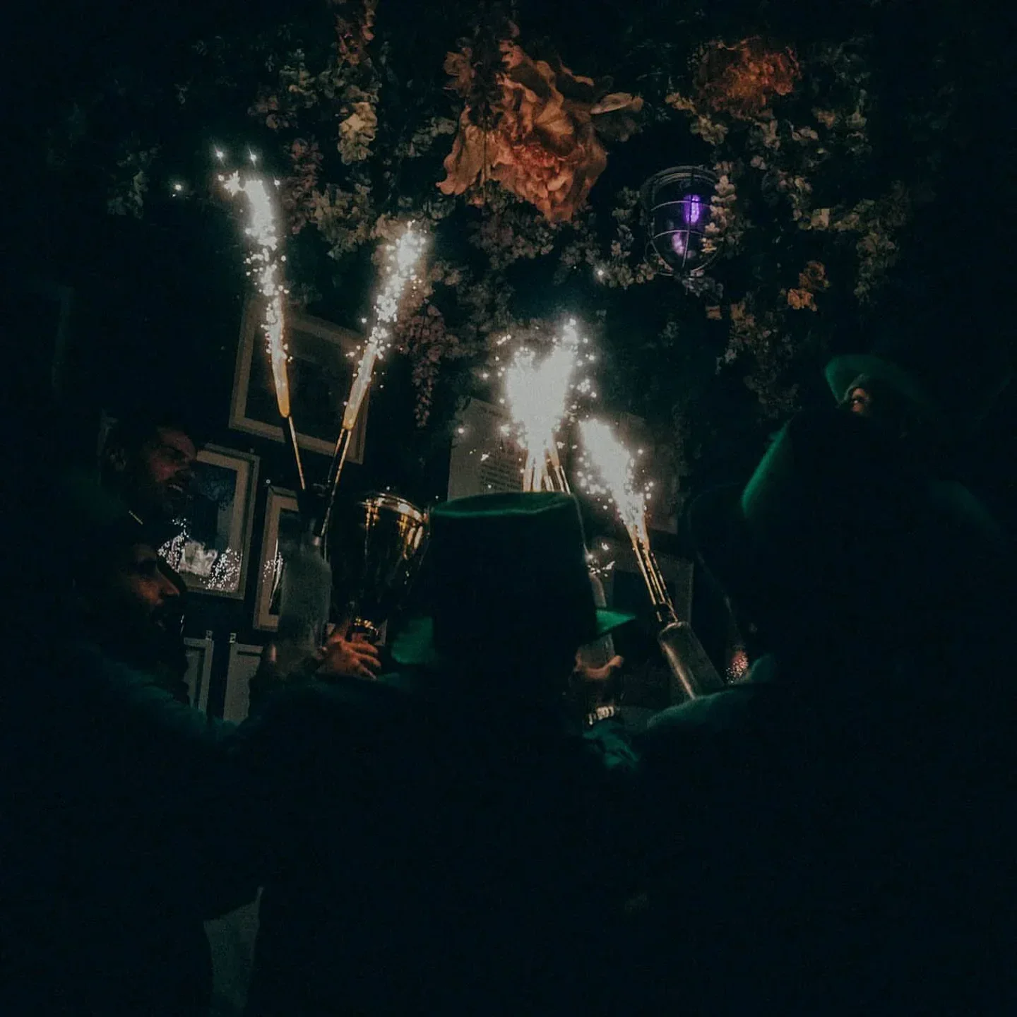 Nightclub celebration with sparklers at Vie i pee in Vienna, floral ceiling decor.