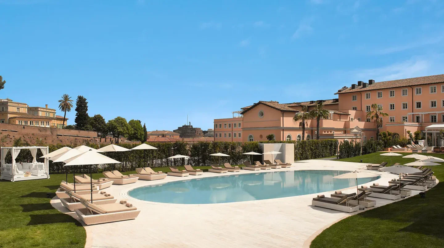 Poolside relaxation at Villa Agrippina a Gran Melià Hotel in Rome with sun loungers and umbrellas.