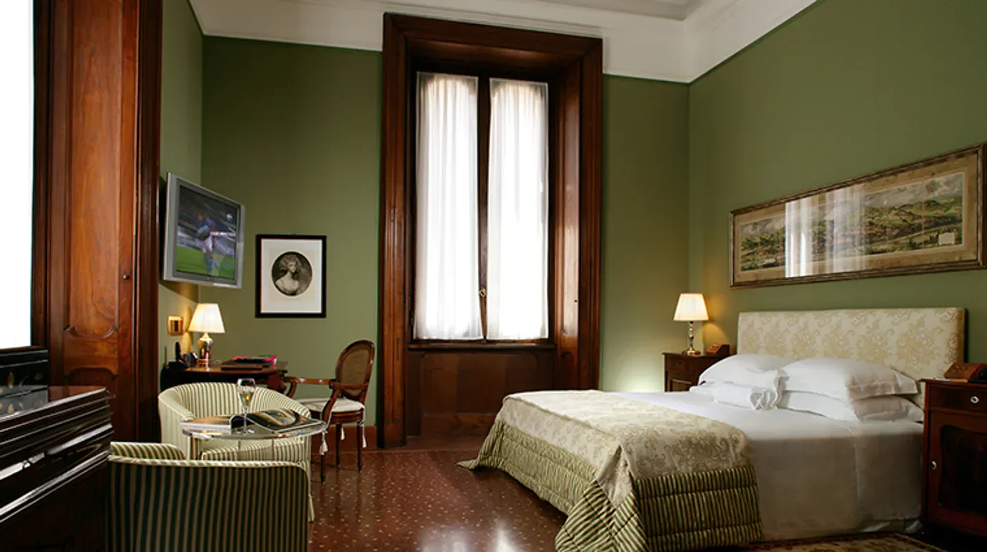 Elegant bedroom at Villa Spalletti Trivelli hotel in Rome, with antique decor.