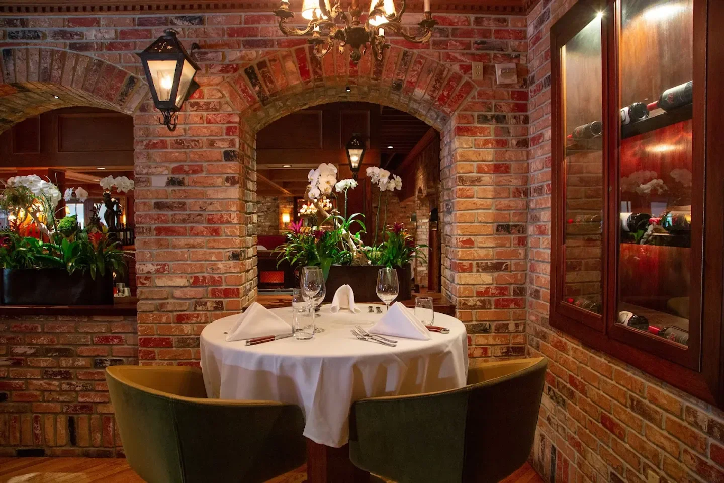 Cozy dining area at Vito's Chop House in Orlando, featuring a brick interior and table setting.