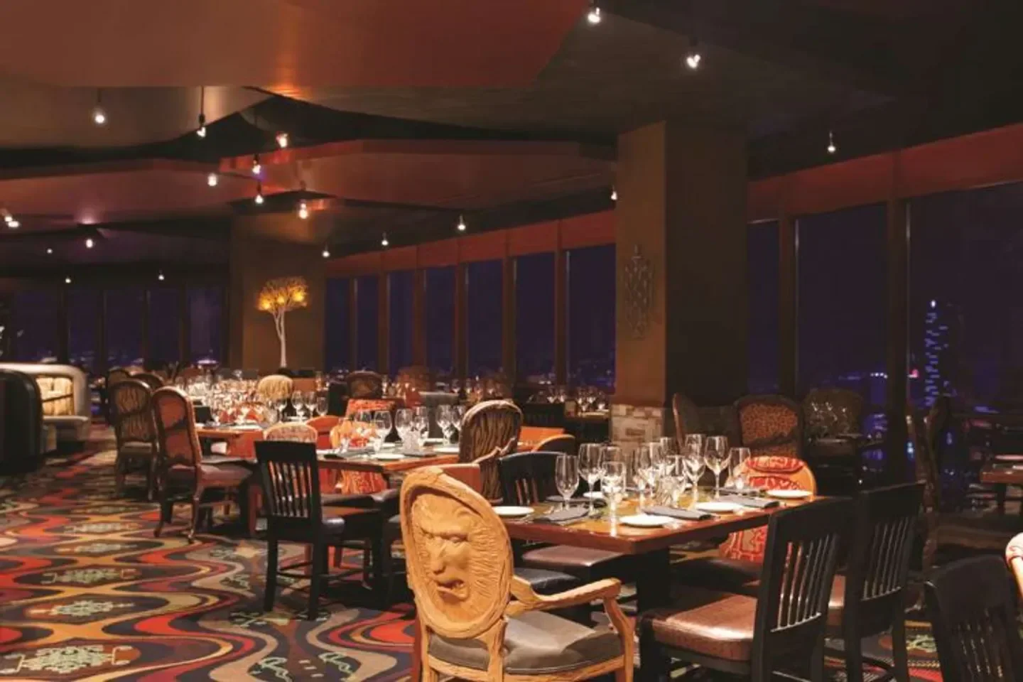 Elegant dining room interior at Voodoo Steakhouse in Las Vegas, with city views at night.