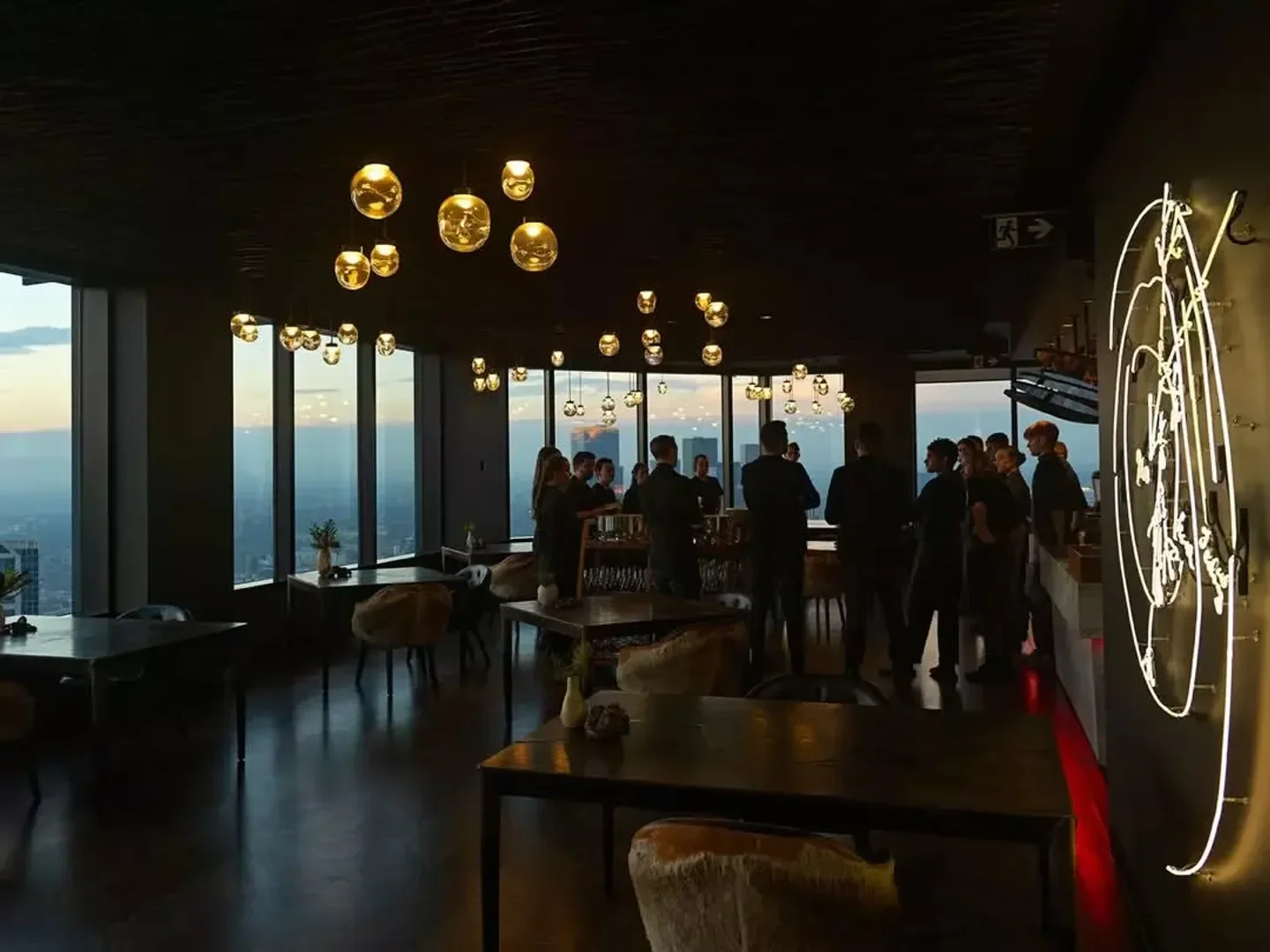 Interior of Vue de Monde restaurant in Melbourne, with sunset view and modern decor.