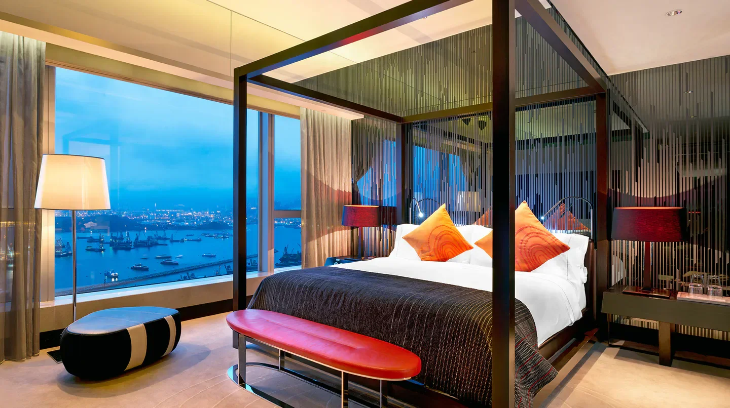 Luxury bedroom at W Hong Kong with stunning city views of Hong Kong at dusk