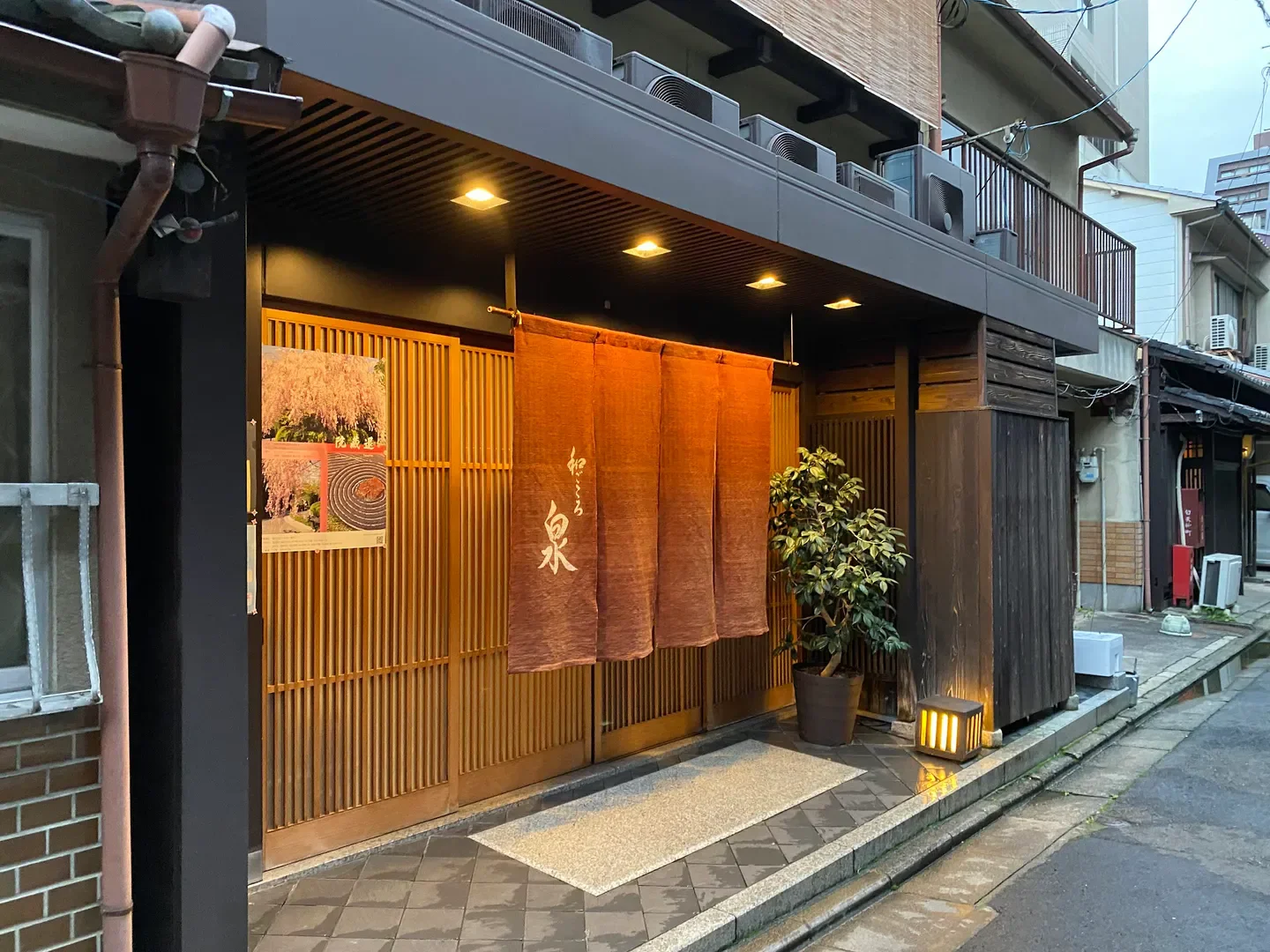 Entrance of Wagokoro Izumi restaurant in Kyoto, featuring wooden facade and traditional decor.