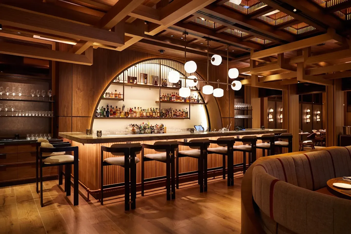 Interior bar at Wakuda restaurant in Singapore, featuring wooden decor and stylish lighting.