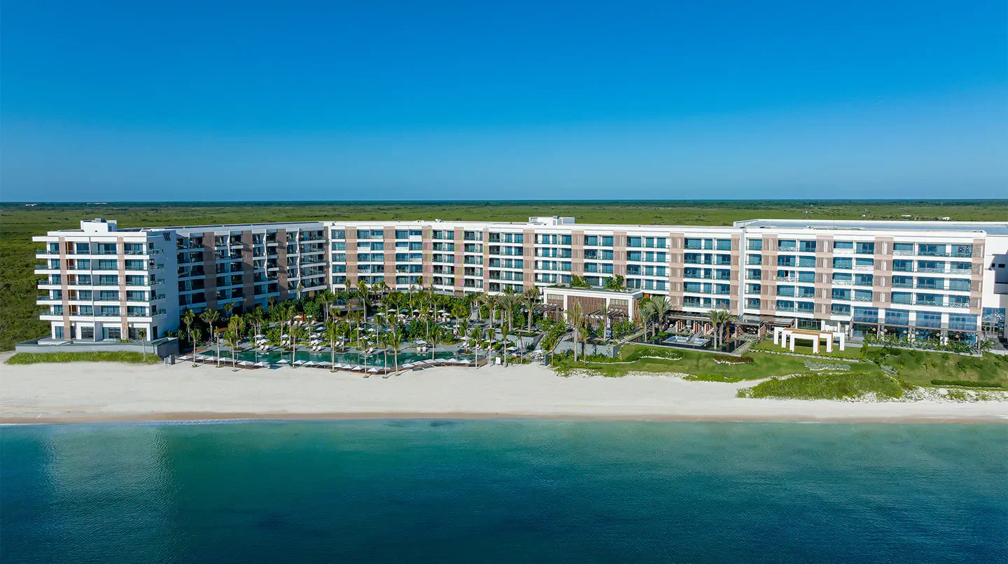 Aerial view of Waldorf Astoria Cancun beachfront hotel with ocean and pool.
