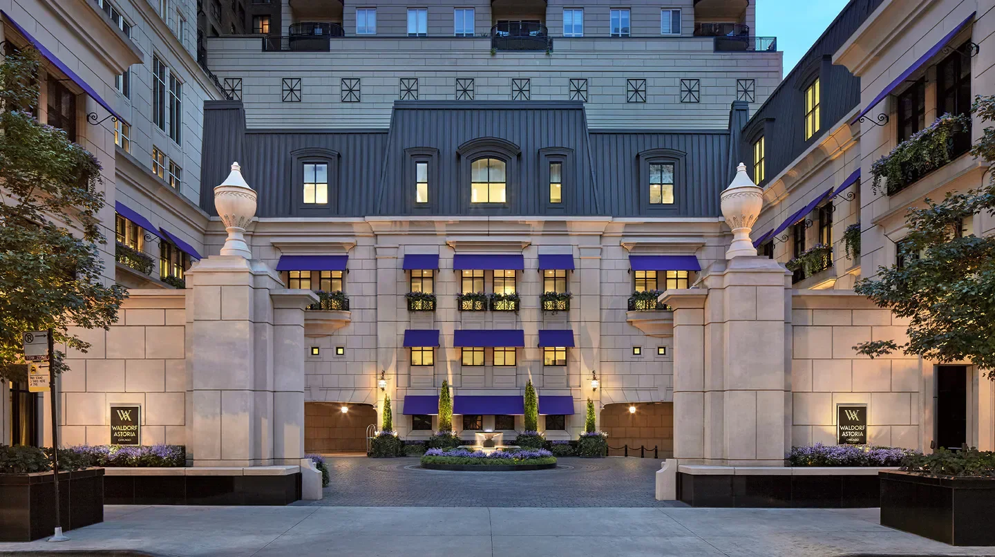Entrance of the Waldorf Astoria Chicago hotel, featuring elegant architecture and water fountain.