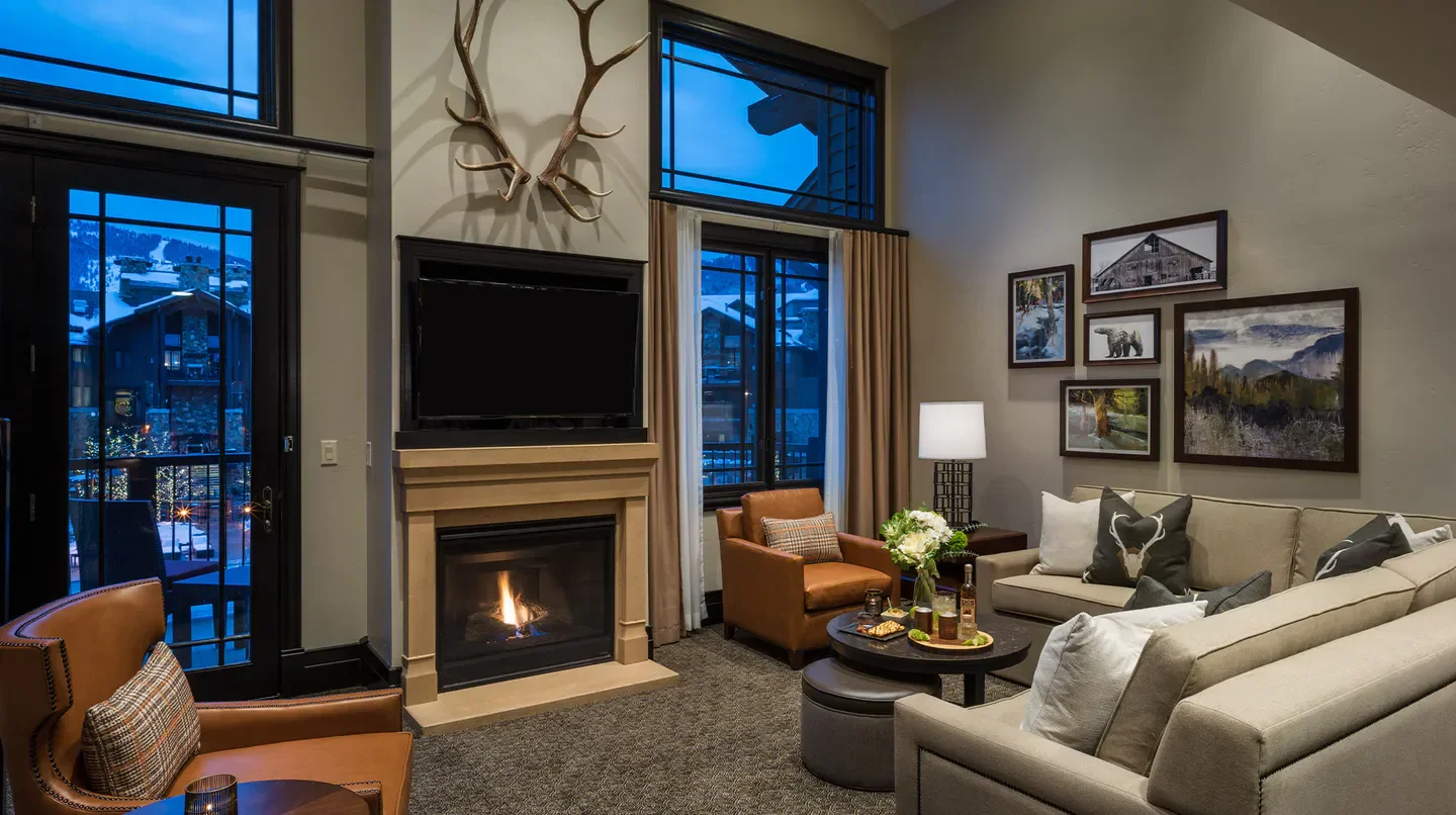 Cozy living room interior at the Waldorf Astoria Park City, with fireplace and views of Park City.