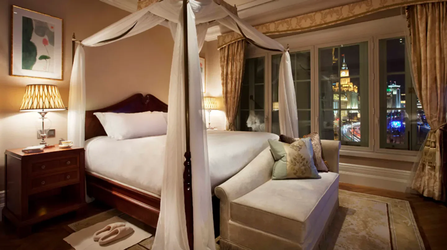Luxury bedroom at Waldorf Astoria Shanghai on the Bund with city views of Shanghai.
