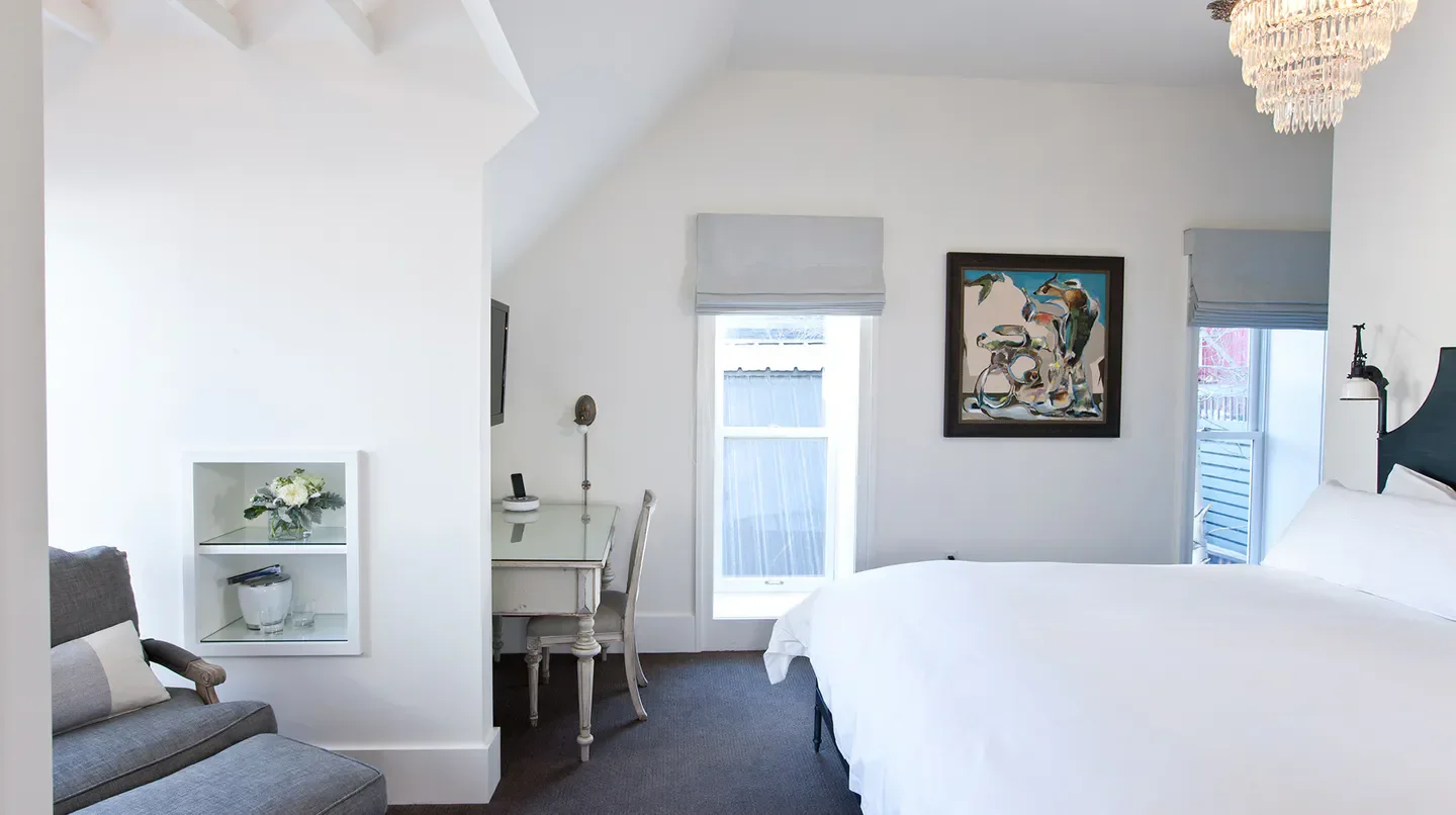 Elegant bedroom at Washington School House Hotel in Park City with artwork and chandelier.