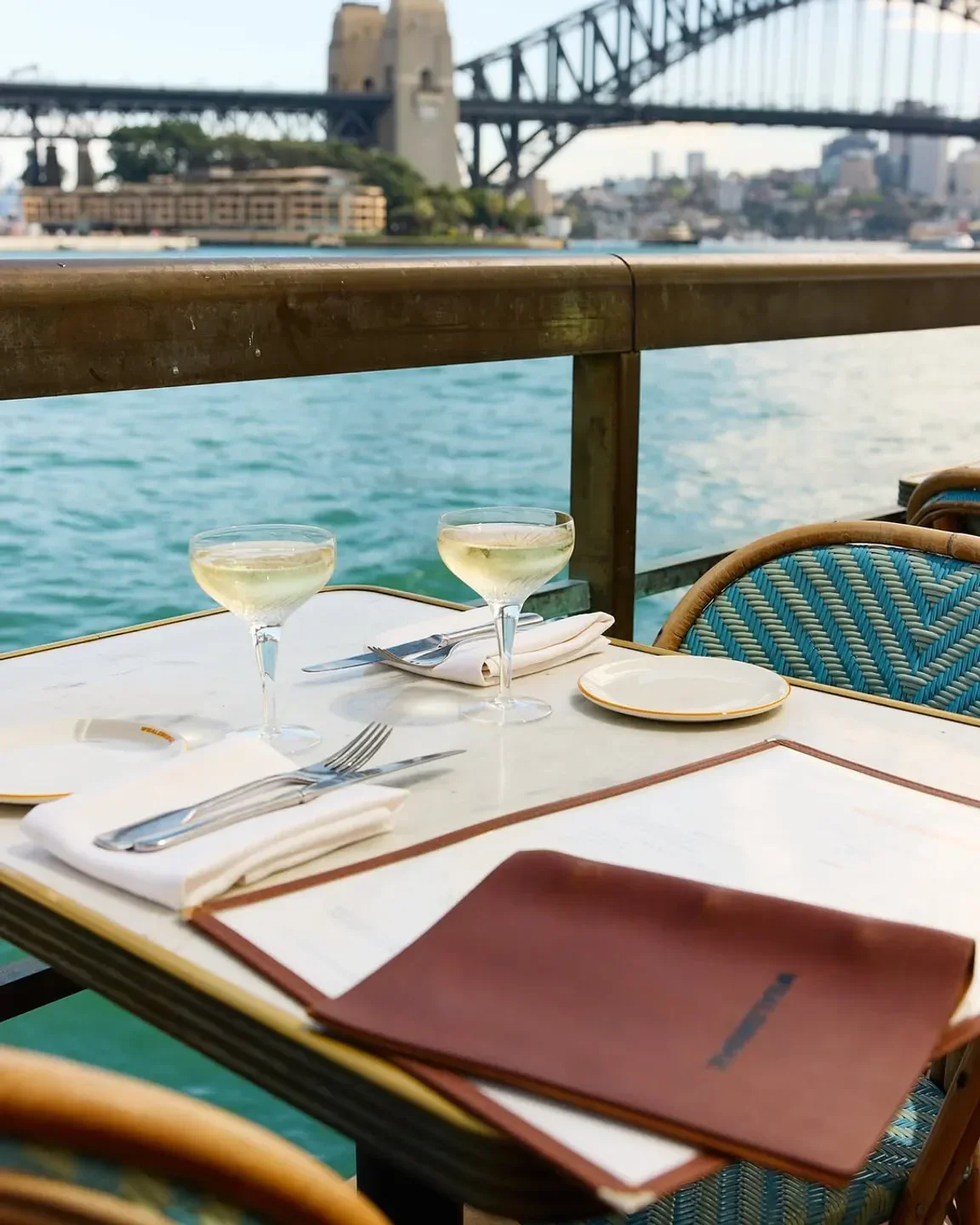 Table setting at Whalebridge restaurant in Sydney with Harbour Bridge view and champagne.