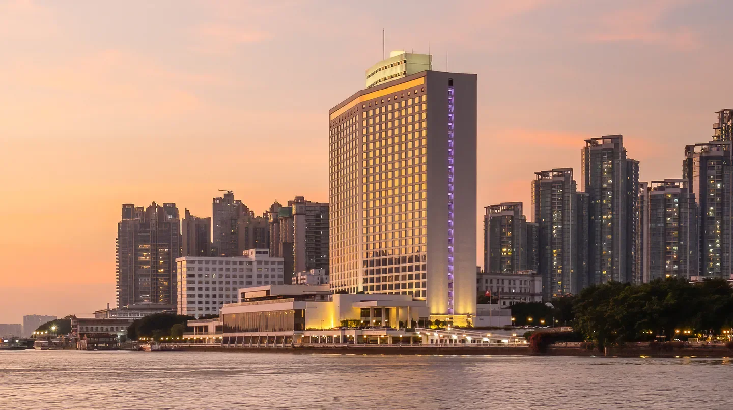 White Swan Hotel in Guangzhou at sunset, a scenic view of the hotel by the water