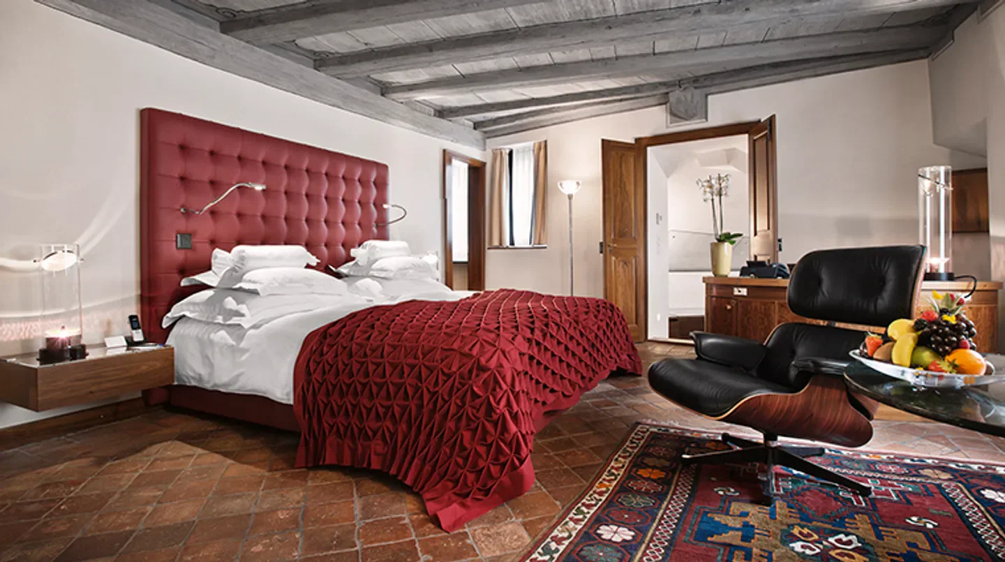 Cozy bedroom interior at Widder Hotel in Zurich, featuring a luxurious red bed