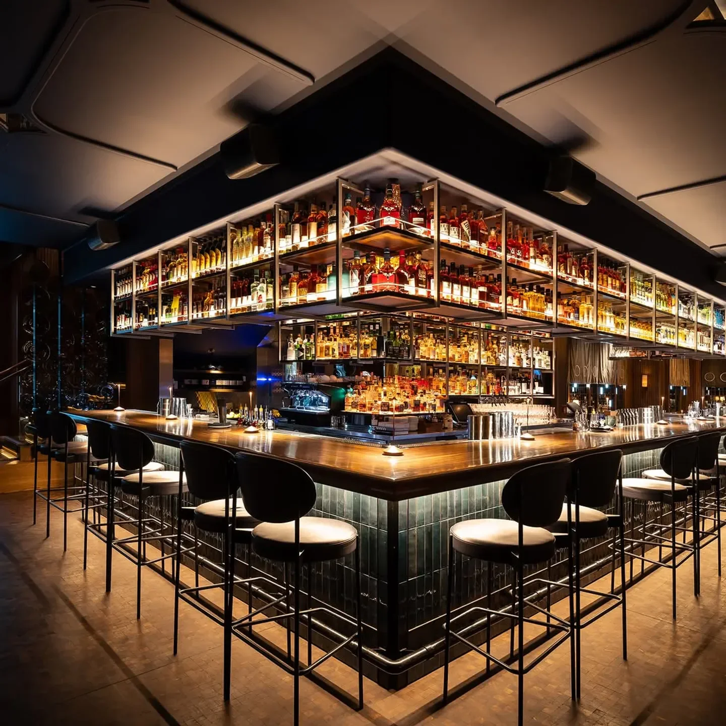 Interior of Wild Blue in Whistler, featuring an elegant bar with bottles and seating.