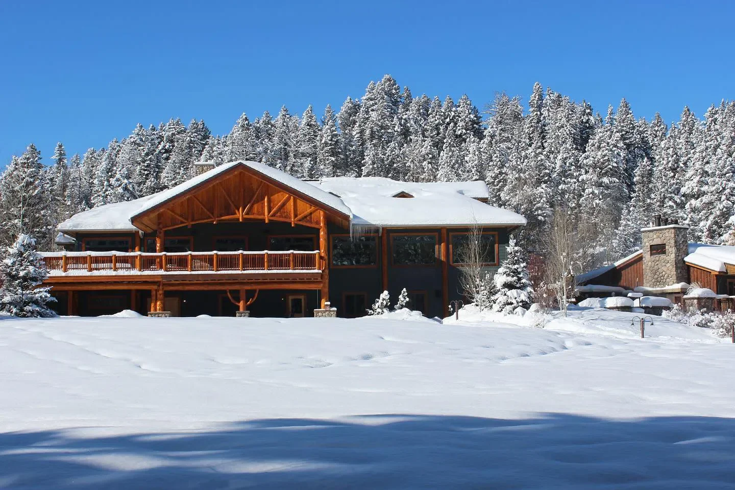 Wild Caddis Restaurant in Southern Montana, snowy exterior in winter season with tall trees.