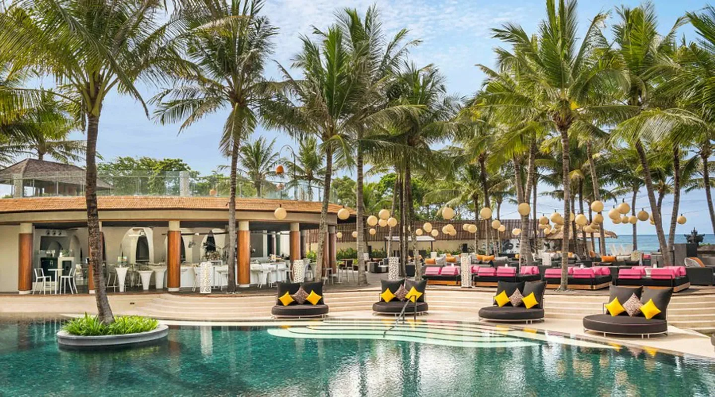 Woobar Bali beach club with pool, loungers, and palm trees in Bali.